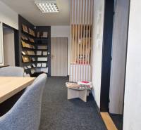 Offices with cream carpet, wooden panels, and material samples on the walls.