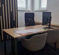 Offices with a desk, swivel chair, and textured wall.