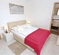 A bedroom in a 3-room apartment with a double bed and light decorations.