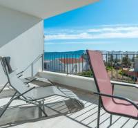 Terrace of a 3-room apartment in Sukošan with a sea view, folding chairs, clear sky.