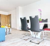 A bright dining room with fresh decor and a wood-patterned floor in a 3-room apartment.
