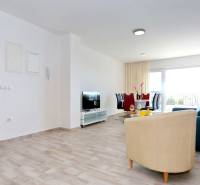 Living room in a three-room apartment with a wooden decor floor and a dining table.