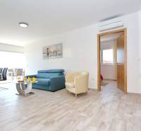 A bright interior of a 3-room apartment with a wooden decor floor and comfortable seating.