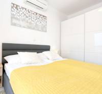 Bedroom in a 3-room apartment with a comfortable bed, nightstand, and air conditioning.