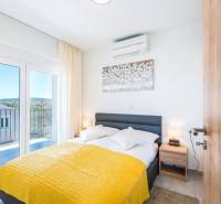 A bedroom in a 3-room apartment with a bed, a balcony, and a bright interior.