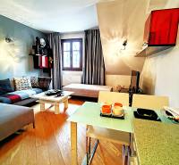 Living room in a two-room apartment with a wooden decor floor and comfortable seating.