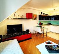 Living room with a kitchenette and a wooden decor floor in a 2-room apartment.