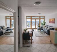 Living room in a two-room apartment with a wood-patterned floor and a comfortable sofa.