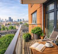 A balcony with a view of the panorama of Bratislava from a 2-room apartment with a wooden decor floor.