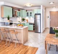 A kitchen in a 2-room apartment with a wooden decor floor and a dining table.