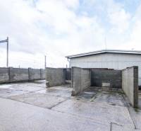 In Šenkvice on Nádražná Street, the photograph shows warehouses and halls with solid concrete walls.