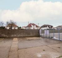 Exterior on Nádražná Street in Šenkvice, next to warehouses and halls with a steel gate.