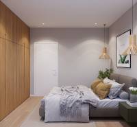 Bedroom in a studio apartment with a bed, a plant, and wooden decor on the floor.