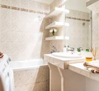 A bathroom with corners in a 3-room apartment, with a shower, sink, and washing machine.