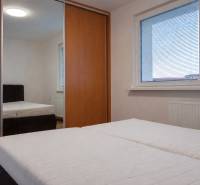 A bedroom in a 3-room apartment with a large window, built-in wardrobe, and a bed.