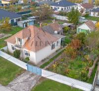 A family house in Veľké Dvorníky with a landscaped garden and surrounding greenery.
