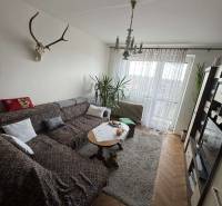 Living room in a 4-room apartment with a corner sofa and a floor with a wooden decor.