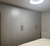 In the 3-room apartment, there are wardrobes with white sliding doors and a bed.