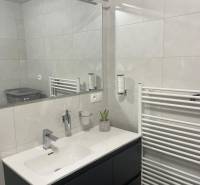 Bathroom in a 3-room apartment with a modern sink, mirror, and radiator.