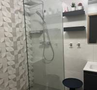 A bathroom in a 3-room apartment with a barrier-free shower and modern tiles.