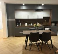 A kitchen in a 3-room apartment with gray cabinets and a wooden decor floor.