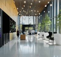 Reception in an office with glass walls, plants, and comfortable seating.