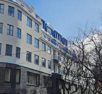 A building in Bratislava - Old Town on Poštová Street with trees in the foreground.