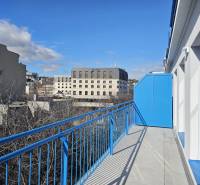A balcony with blue railings offers a view of buildings in Bratislava - Old Town.
