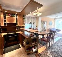Interior of a family house with a kitchen unit, dining table, and floor with a wooden decor.