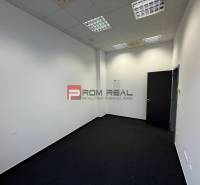 Offices with white walls and dark carpet.