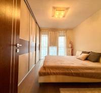 Bedroom in a 2-room apartment with a large bed and a floor with a wooden decor.