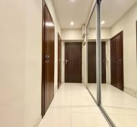 A hallway with a white floor and a mirrored wardrobe in a 2-room apartment.