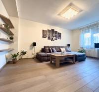 Living room in a two-room apartment with a wooden decor floor and a comfortable sofa.