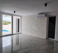 Living room with marble floor and sliding doors in a family house.