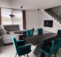 Living room in a family house with a dark table and turquoise chairs.