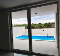 View from the family house to the terrace with a pool, floor with wooden decor.