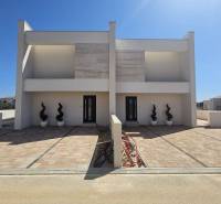 A family house on Mulo Street in Vrsi with a paved walkway and decorative plants.