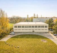 A building surrounded by greenery and a parking lot in Bratislava - Ružinov on Šándorova Street.