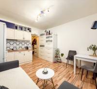 Studio apartment with a kitchenette, table, and floor with a wooden decor.