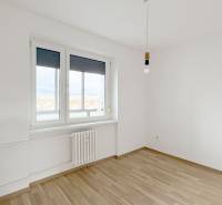 A room in a 3-room apartment with a wooden decor floor and white walls.