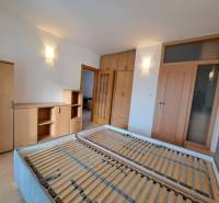 A bedroom in a 4-room apartment with wooden decor furniture and a bed without a mattress.