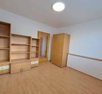 A room in a 4-room apartment with furniture and a floor with a wood decor.