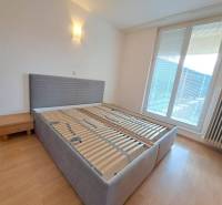 Bedroom in a 4-room apartment with a bed and a nightstand, floor with wood decor.