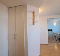 Interior of a 4-room apartment with a wooden decor floor and a modern wall hanger.
