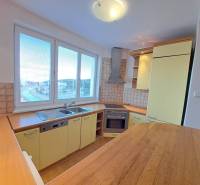 A kitchen in a 4-room apartment with built-in appliances and a floor with a wooden decor.