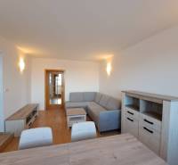 Living room in a 4-room apartment with a wooden decor floor and a gray sofa.