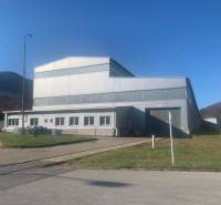 Production facilities in Dobšiná with a steel structure surrounded by natural scenery and grassy areas.