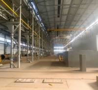 Production facilities with metal structures and a crane inside the hall.