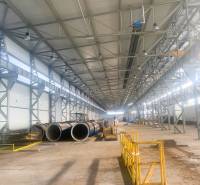 Production facilities with metal structures and piping, Dobšiná. A wide hall with yellow barriers.