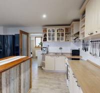 A kitchen in a family house with a wooden decor and a spacious work surface.